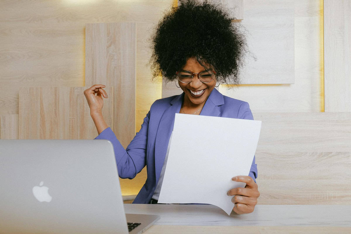 Confident AS Genotype woman smiling while reading her genetic report, symbolizing empowerment